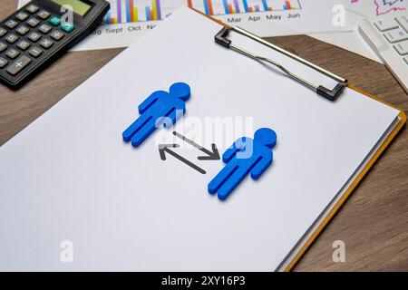 Due figure blu su una clipboard, rivolte l'una verso l'altra con frecce che puntano in entrambe le direzioni. Ciò simboleggia il concetto di rotazione del lavoro. Foto Stock