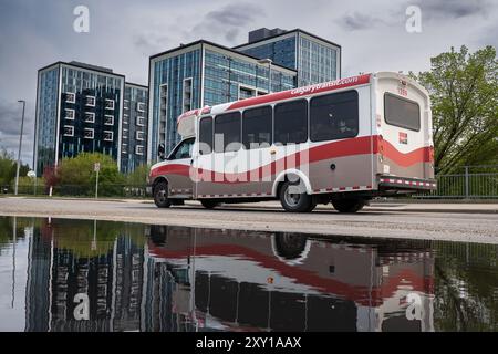 Calgary, Alberta Canada, 20 giugno 2024: L'autobus parte dalla stazione di transito di Dalhousie accanto agli appartamenti che trasportano pendolari giornalieri. Foto Stock