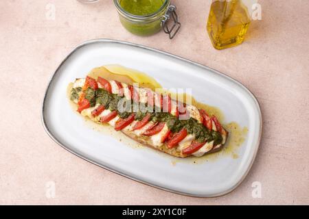 Melanzane al forno con mozzarella, pomodori e salsa al pesto. Piatto tradizionale di stagione fatto in casa. Melanzane ripiene grigliate. Abbondante piatto estivo. SEL Foto Stock