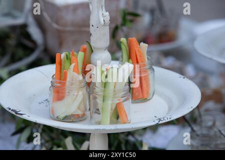 Le verdure fresche sono preparate per l'immersione e visualizzate su un vassoio rustico bianco Foto Stock