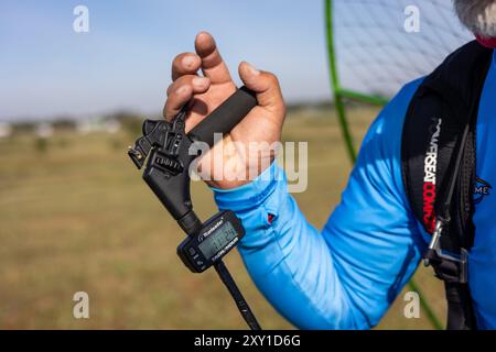 Pilota che controlla l'equipaggiamento di parapendio prima del volo. Foto Stock