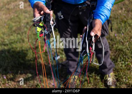 Pilota che controlla l'attrezzatura di parapendio motorizzata. Foto Stock