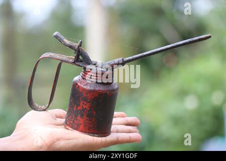 Barattolo di olio che sembra molto vecchio e sporco tenuto in mano Foto Stock