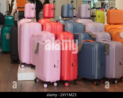 Una gamma di valigie colorate in vendita in un deposito bagagli, preparazione per il viaggio. Foto Stock