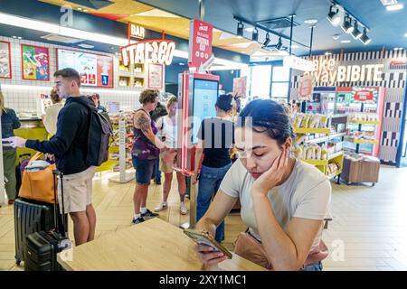 Pisa Italia, Piazza della stazione, stazione centrale, interni, lettura di messaggi di testo, cellulare, Bar Italico Cafe Foto Stock