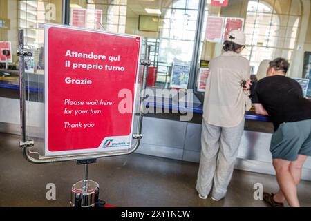 Pisa Italia, Piazza della stazione, stazione ferroviaria centrale di Pisa, interno, sportello biglietteria Trenitalia, man Woman, cartello no Foto Stock