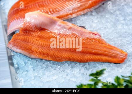 Filetto di trota di salmone su ghiaccio tritato esposto sul bancone del pescivendolo Foto Stock