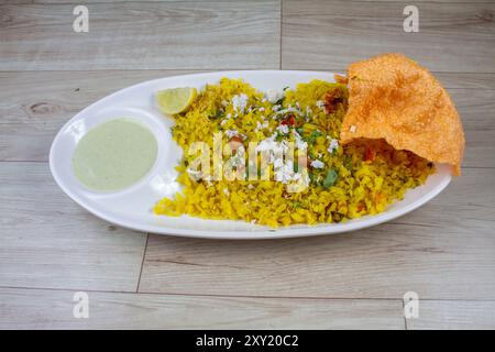 Kande Pohay O Aloo Poha è una popolare ricetta indiana per la colazione, preparata con riso appiattito, solitamente servito. Messa a fuoco selettiva Foto Stock