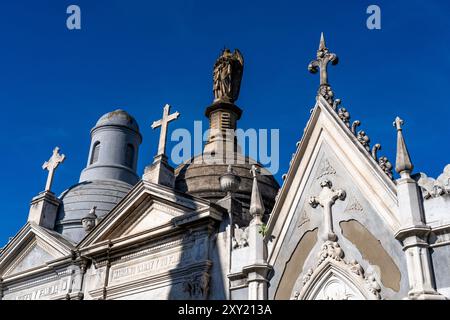 Croci e una statua su elaborate tombe o mausolei nel Cimitero di Recoleta, Buenos Aires, Argentina. Foto Stock