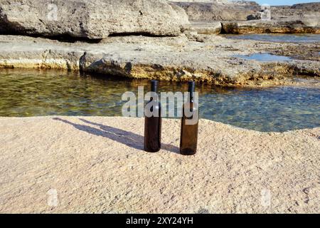 Due bottiglie di vino sulla costa rocciosa del Mar Caspio. Foto Stock