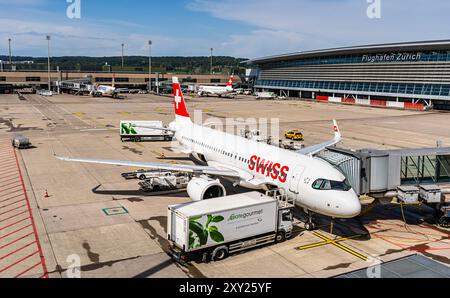 Ein Airbus A220-100 von Swiss International Airlines con Am Terminal B des Flughafen Zürich abgefertig. Gategourmet liefert beispielsweise Die Verpfl Foto Stock