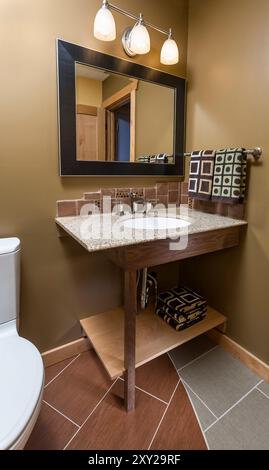 Piccolo bagno con lavandino personalizzato e interessante combinazione di pavimento piastrellato Foto Stock
