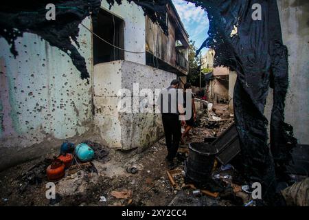 Tulkarm, Palestina. 27 agosto 2024. I palestinesi ispezionano i danni causati dagli attacchi aerei israeliani al campo profughi di Nour Shams. L'aeronautica militare israeliana ha bombardato un edificio nel campo profughi di Nour Shams, distruggendo diverse case e strade vicine e uccidendo cinque giovani uomini. Credito: SOPA Images Limited/Alamy Live News Foto Stock