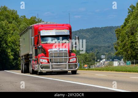 Knoxville, Tennessee, Stati Uniti – 20 agosto 2024: Ripresa orizzontale di un semirimorchio rosso a 18 ruote su un'autostrada interstatale nella calura estiva. Ciao Foto Stock