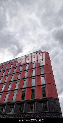 Basso angolo di dettaglio della facciata dello sviluppo della Ilona Rose House su Charing Cross Road, Londra sotto un cielo bianco con ragnatele di nuvole retroilluminate da t Foto Stock
