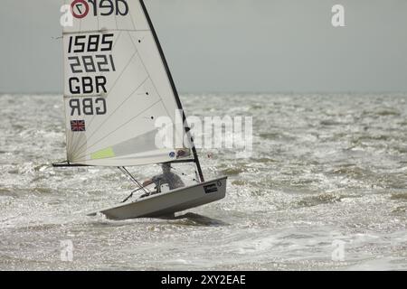 I marinai vengono testati da un mare agitato e da forti venti durante la Dinghy Racing a Hythe, Kent, il 26 agosto 2024, nei giorni festivi. Foto Stock