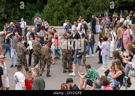 Parigi, Francia - 07 14 2024: Quartiere di Montmartre. Vista di un gruppo di soldati che cammina tra i turisti in piazza Louise Michel Foto Stock