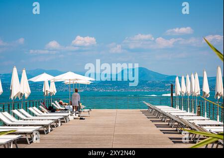 Vista della località turistica con ombrelloni e lettini a Sirmione sul Lago di Garda, Italia. Foto Stock