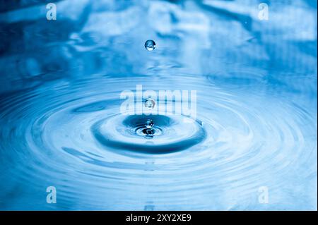 Gocce d'acqua cadono sulla superficie dell'acqua Foto Stock