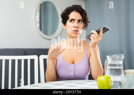 Positiva donna bruna gioiosa che parla sul telefono cellulare Foto Stock