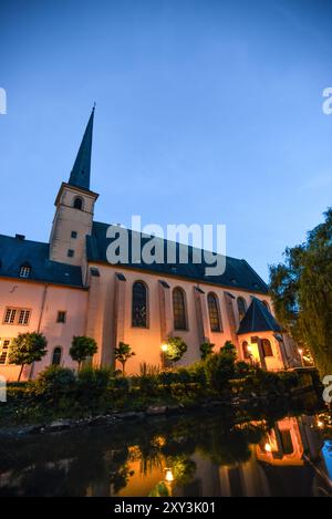 Vista serale dell'Abbazia di Neumünster illuminata che si riflette sul fiume Alzette a Grund, città di Lussemburgo Foto Stock