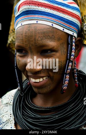 La Peul / Fula / Fulani donne decorano le loro facce e corpi con tatuaggi colorati. Foto Stock