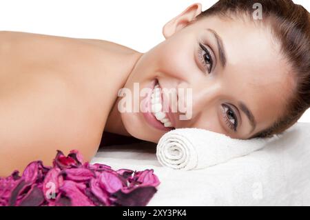 Giovane donna giacente in una spa pronto per ottenere un massaggio, isolato in bianco Foto Stock