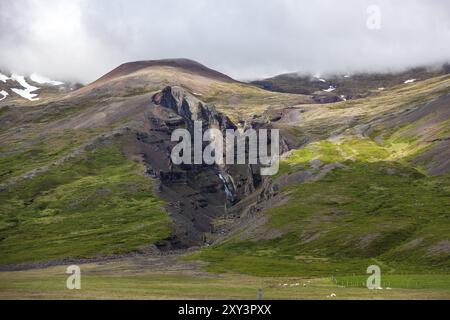 Crepa su una montagna con una piccola cascata che scorre giù sull'Islanda Foto Stock