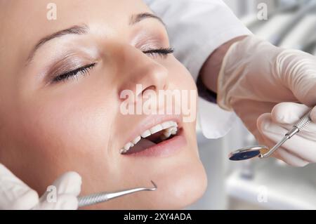 Primo piano di un dentista mani circa per eseguire un intervento su un paziente Foto Stock