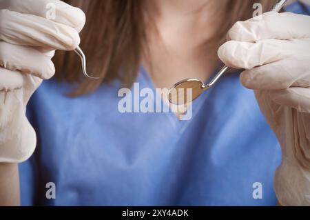 Primo piano di un dentista mani circa per eseguire un intervento su un paziente Foto Stock