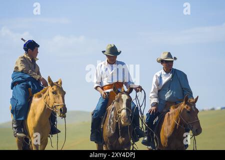 Ulan Bator, Mongolia, 12 giugno 2007: Tre cowboy mongoli a cavallo si avvicinano a cavallo a cavallo in abiti tradizionali e cappelli da cowboy, Asia Foto Stock