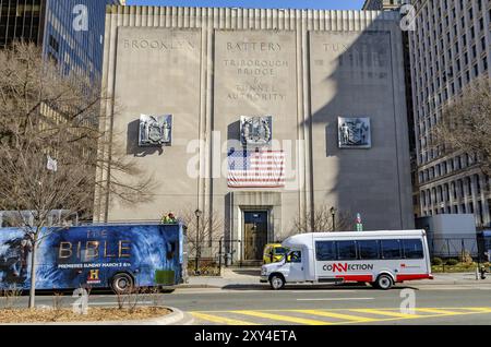 Ingresso dell'edificio dell'autorità del tunnel di New York City con strada e autobus di fronte durante l'inverno vista ad angolo basso, orizzontale Foto Stock