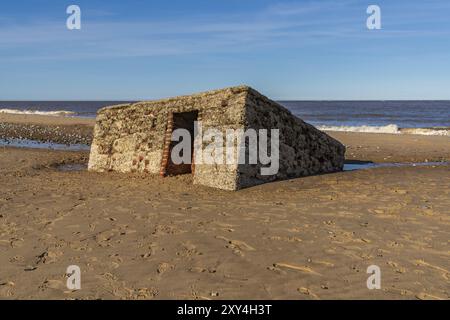 Costa del Mare del Nord a Caister-on-Sea, Norfolk, Inghilterra, Regno Unito, con un vecchio bunker sulla spiaggia Foto Stock