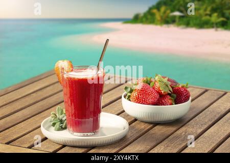 Vacanza Scena con fresco frullato fragole e spiaggia tropicale a sfondo sulla giornata di sole. Vacanza o il concetto di tempo libero Foto Stock