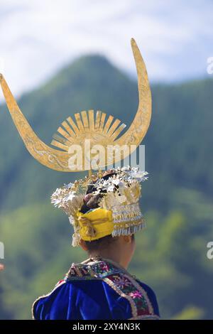 Xijiang, Cina, 15 settembre 2007: Vista posteriore dettagliata della donna Miao della minoranza etnica in tradizionale copricapo di corno d'argento e costume da festival a Xiji Foto Stock