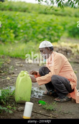 Povero contadino indiano felice che beveva acqua Foto Stock