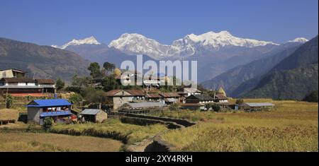 Villaggio nepalese e catena montuosa di Manaslu innevata Foto Stock