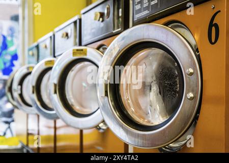 Fila di macchine di lavaggio in una lavanderia a gettoni Foto Stock