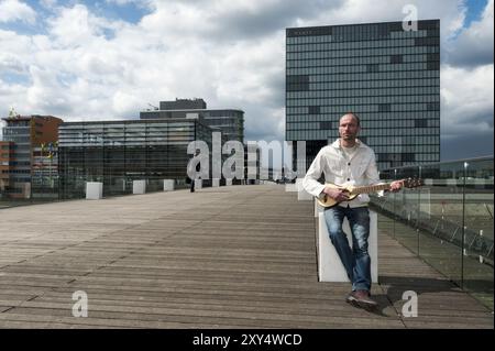 Giovane con la chitarra nel Media Harbour di Duesseldorf Foto Stock