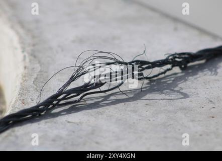 pezzo di filo nero sfilacciato Foto Stock