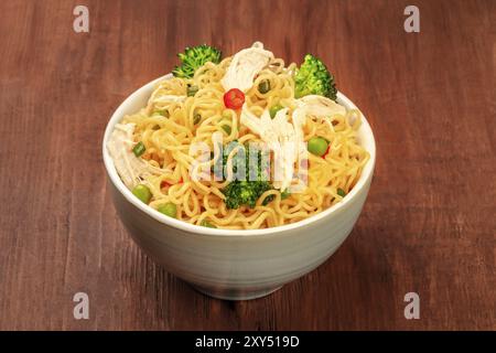 Soba Noodles con verdure e carne di pollo al buio su un rustico sfondo di legno Foto Stock