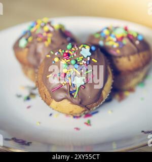 Tortini dolci fatti in casa su un piatto con decorazioni colorate Foto Stock