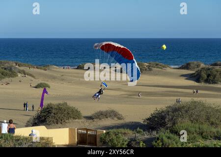 Un tandem paracadute atterra tra le dune al largo di Playa del Ingles Foto Stock