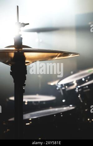 Primo piano tamburo in una stanza buia contro lo sfondo del riflettore. Sfondo atmosferico simbolo della musica rock o jazz. Piastre in rame su Foto Stock