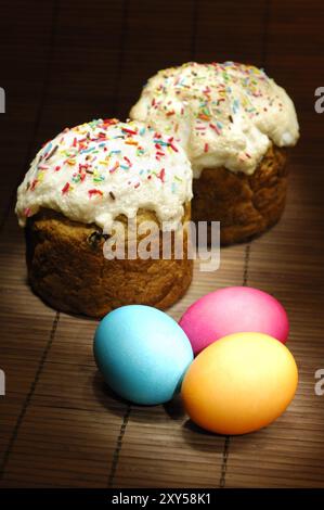 Dipinto con dolci di Pasqua chiari e uova di Pasqua colorate natura morta artistica festiva su sfondo scuro orientamento verticale Foto Stock