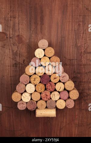 Un albero di Natale fatto di tappi vino al buio su un rustico sfondo di legno con un posto per il testo. Un anno nuovo biglietto di auguri o invito degustazione di te di design Foto Stock