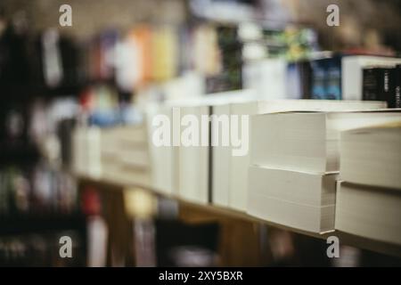 Una pila di libri, sfondo sfocato: Mercato delle pulci dei libri di beneficenza, al chiuso. Spazio di testo Foto Stock