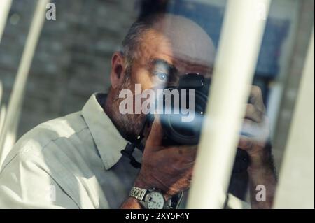 Fotografo nascosto dietro le tapparelle Foto Stock