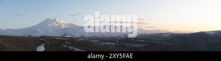 Panorama serale del paesaggio a nord di prielbrusya subito dopo il tramonto. Ora blu. Vulcano innevato Elbrus. Caucaso settentrionale. Russia Foto Stock