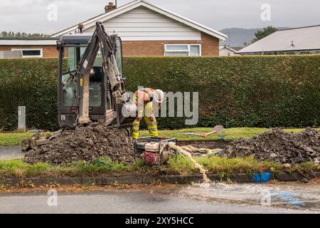Una rete idrica in fase di riparazione nella città di confine gallese di Presteigne, Powys, da parte di un team di Dŵr Cymru (acqua gallese) Foto Stock